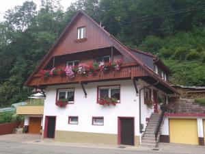 a white house with flowers on the roof at Ferienwohnung Sonnenblick in Oberharmersbach +14 photos