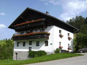 ein weißes Gebäude mit Blumen auf der Seite in der Unterkunft Feichtingerhof in Steinbach am Attersee