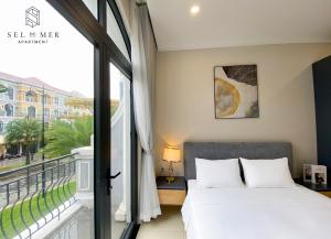 1 dormitorio con cama y ventana grande en Sel de Mer Apartment Grand World Phu Quoc en Phu Quoc