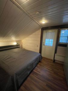 a bedroom with a bed in a room with wood floors at Levi Unelma Villa in Levi
