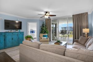 ein Wohnzimmer mit einem Sofa und einem Deckenventilator in der Unterkunft Heron 507- A Wave From It All in Fort Walton Beach