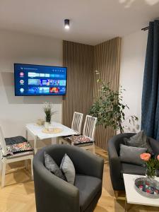 a living room with two chairs and a tv at EXPO KRUPÓWKI 60 APARTMENT in Zakopane