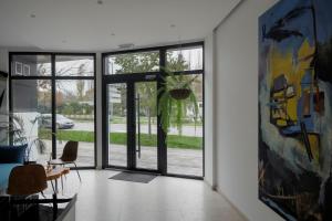 uma sala de estar com uma porta de vidro com uma planta em WellNS Rooms em Novi Sad