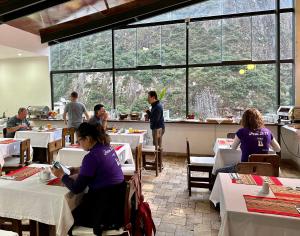 een groep mensen die aan tafel zitten in een restaurant bij Hatun Inti Classic in Machu Picchu