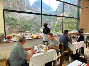 a group of people sitting at tables in a restaurant at Hatun Inti Classic in Machu Picchu
