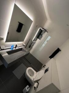 a bathroom with a toilet and a sink and a mirror at Bedouin Break Condo - In the Heart of Amman in Amman