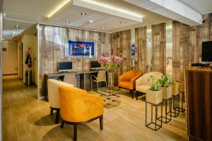 a living room with chairs and a desk with a television at Rado Hotel - Santa María in Trujillo