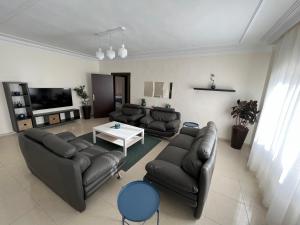 a living room with leather couches and a table at Bedouin Break Condo - In the Heart of Amman in Amman