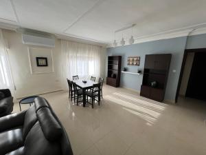 a living room with a couch and a table and chairs at Bedouin Break Condo - In the Heart of Amman in Amman