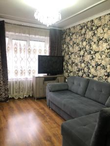 Il comprend un salon doté d'un canapé et d'une télévision à écran plat. dans l'établissement Уютная квартира у парка, à Chişinău