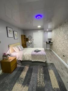 a bedroom with a large bed and a purple light at Private bedroom near NEC, Birmingham airport,city centre in Birmingham