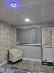 - un salon avec une chaise et une fenêtre dans l'établissement Private bedroom near NEC, Birmingham airport,city centre, à Birmingham