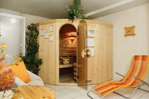 a wooden cabinet in a room with a table and chairs at Landpension Risch in Ilmenau