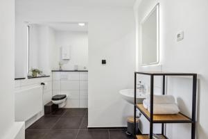 La salle de bains blanche est pourvue de toilettes et d'un lavabo. dans l'établissement Mark 51-7 - Workplace - Netflix - Washer Dryer - Modern Design, à Bochum