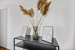 a black table with a vase with dried grass at Mark 51-7 - Workplace - Netflix - Washer Dryer - Modern Design in Bochum