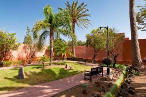 a park with palm trees and a park bench at Villa Candela AirPort in Ingenio