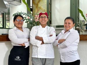 drie vrouwen in een keuken met gekruiste armen bij Hatun Inti Classic in Machu Picchu