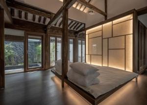 ein Schlafzimmer mit einem großen Bett mit weißen Kissen in der Unterkunft Present Stay in Jeonju