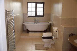 a bathroom with a tub and a toilet and a window at The Kyoto House - Four Spacious Cosy Bedrooms I Contractor Friendly I Long Stay Offer I 5th Room available on request only in Derby