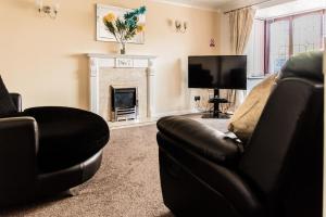 a living room with a couch and a fireplace at The Kyoto House - Four Spacious Cosy Bedrooms I Contractor Friendly I Long Stay Offer I 5th Room available on request only in Derby