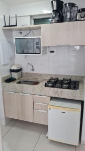 a white kitchen with a stove and a microwave at ISRAEL FLAT DUPLEX C/ PISCINA in João Pessoa