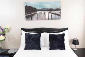 ダービーにあるThe Kyoto House - Four Spacious Cosy Bedrooms I Netflix & Large Roomsのベッドルーム(白いベッド、黒い枕付)