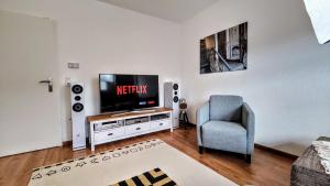 a living room with a television and a chair at YourFavoriteBed 100m2 Designwohnung mit Vollausstattung in Plauen