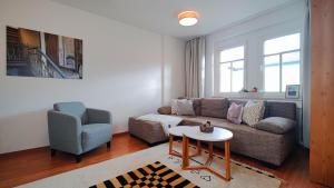 ein Wohnzimmer mit einem Sofa, einem Stuhl und einem Tisch in der Unterkunft YourFavoriteBed 100m2 Designwohnung mit Vollausstattung in Plauen