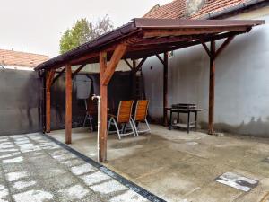 - un pavillon avec des chaises et une table sur la terrasse dans l'établissement Signal Suites with Garden & Mountain View, à Braşov