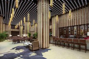 a lobby with chairs and tables in a building at Ramada Plaza by Wyndham Xi'an South in Xi'an