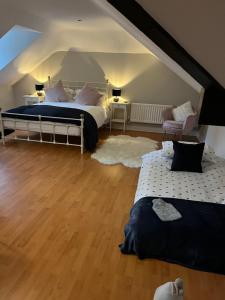 a bedroom with a bed and two chairs in a attic at The Pheasantry - guest house in beautiful rural location in Aldermaston