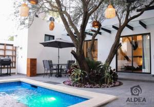 un patio con piscina, un árbol y una mesa en VILLA HUIZACHE ALBERCA PRIVADA+EXCLUSIVIDAD+LUJO, en San Martín de las Pirámides