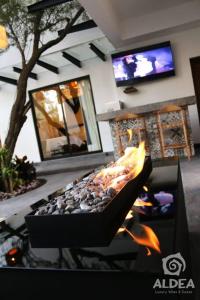 chimenea en la sala de estar con TV en VILLA HUIZACHE ALBERCA PRIVADA+EXCLUSIVIDAD+LUJO, en San Martín de las Pirámides