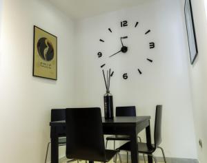 uma mesa e cadeiras com um relógio na parede em Bragadin75 In Vaticano em Roma