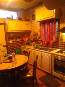 a kitchen with yellow cabinets and a table and a sink at Maison de rêve in Tabarka