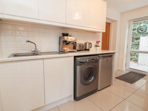 a kitchen with a washing machine and a sink at Hafan Fach in Mold