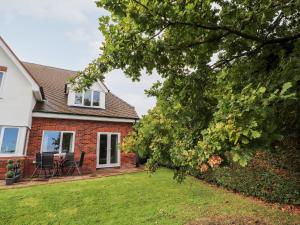 a house with a yard with chairs and a tree at Hafan Fach in Mold