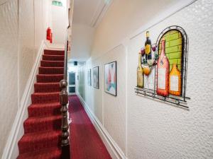 um corredor com uma escada vermelha com um quadro na parede em St Kildas, Blackpool Central em Blackpool