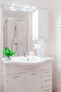 a white bathroom with a sink and a mirror at Stranachwirt Apartments in Sankt Michael im Lungau