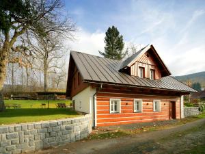 Cette petite maison en bois est dotée d'un mur en pierre. dans l'établissement Apartmány mlýn, à Rokytnice nad Jizerou