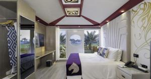a bedroom with a large bed and a large window at Anavrin Equestrian Retreat in Ras al Khaimah