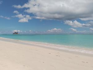 a beach with the ocean and clouds in the sky w obiekcie Royal Bay Villa w mieście Anse Royale