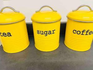 three yellow buckets with the words sugar and coffee on them at Cheerful newly refurbed 5 bed! in Derby