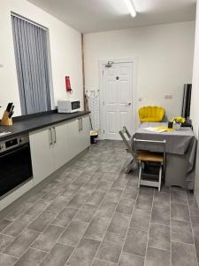 a kitchen with a table and chairs in a room at Cheerful newly refurbed 5 bed! in Derby