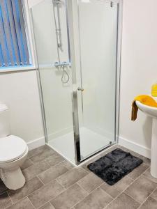 a bathroom with a shower and a toilet and a sink at Cheerful newly refurbed 5 bed! in Derby