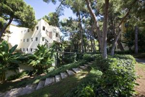 a white house with trees and bushes in front of it at Limak Arcadia Sport Resort Belek in Belek