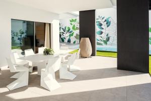a white dining room with a white table and white chairs at Villa Eden in Adeje
