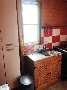 uma pequena cozinha com um lavatório e uma janela em On Planet em Coquimbo