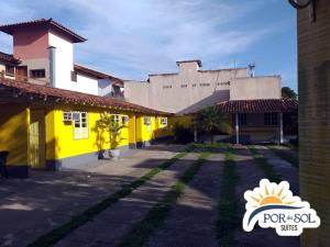 un bâtiment avec un bâtiment jaune et blanc dans l'établissement Suites por do Sol, à Búzios