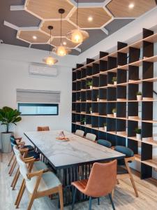una mesa y sillas en una habitación con una pared de estanterías en Ocean Guest House en Magong